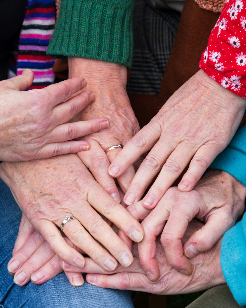 A close up picture of several people's hands of different age groups